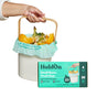 A hand holds a small compost bin lined with HoldOn Bags Compostable Small Space Bags, 4 gal - Unscented, filled with food scraps. In front is a HoldOn Bags box displaying product images and details.