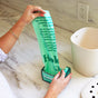 A person pulls a HoldOn Bags Compostable Small Space Bag, 4 gal - Unscented, from the box near a white countertop compost bin in the kitchen.