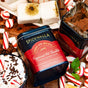 Spicewalla Deluxe Hot Chocolate - Peppermint tin, made with rich Guittard cocoa, surrounded by candy canes, marshmallows, and a festive mug topped with whipped cream and chocolate sprinkles.