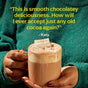 A person in a green sweater holds a mug of hot chocolate topped with whipped cream and marshmallows, made with Diaspora Spice Co.’s Hot Cocoa Drink Mix—a rich blend infused with single-origin spices. Text above reads: This is smooth chocolatey deliciousness. How will I ever accept just any old cocoa again? – Katy.