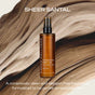 A brown bottle of Ember Wellness Hydrating Body Oil stands upright on a silky beige and brown marbled background, highlighting its gentle, allergen-free formula for sensitive skin—ideal as a nourishing massage oil.