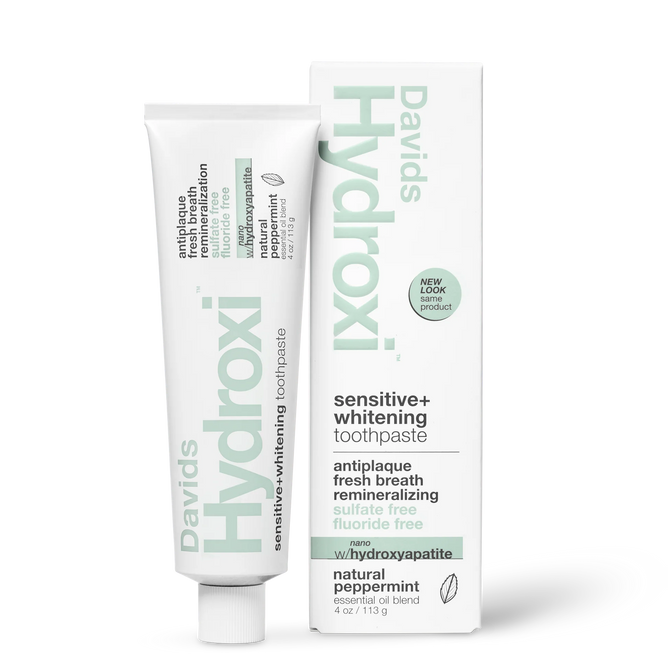 A tube and box of Davids Hydroxi™ Premium toothpaste - Sensitive + Whitening w/nano hydroxyapatite in natural peppermint flavor. The white packaging features mint-green and black text, highlighting the benefits of this sensitive whitening toothpaste, which is fluoride-free, sulfate-free, and anti-plaque.