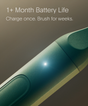 Close-up of the SURI 2.0 Sonic Toothbrush with UV Travel Case by SURI. Text reads: “1+ Month Battery Life. Charge once. Brush for weeks.” The metallic design features a glowing light for a cutting-edge brushing experience.