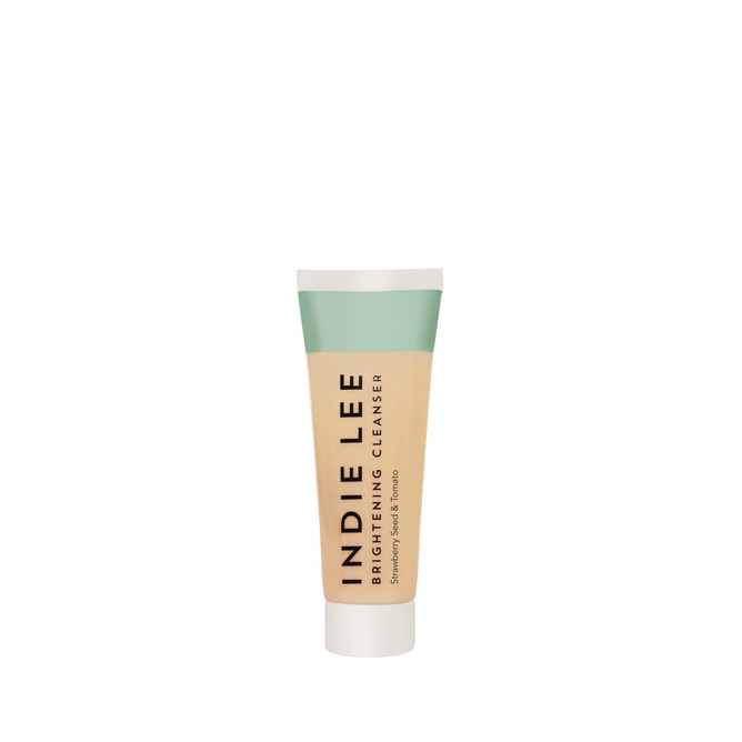 The Indie Lee Brightening Cleanser - Travel stands upright with a green and beige design on a white background, highlighting its clean skincare benefits.