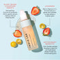 A bottle of Indie Lee Brightening Cleanser - Travel rests on a light blue background with tomato and strawberry halves, highlighting clean skincare with plant-based cleansers, lycopene, and antioxidants for a radiant complexion.