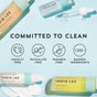 Flat lay of Indie Lee Bronzing Drops on a light blue background with icons and text: Committed to Clean, cruelty free, phthalate free, paraben free, and 1300+ banned ingredients—ideal for hydrating skin and a summer glow.