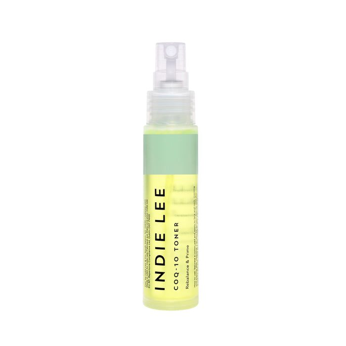 A clear spray bottle of Indie Lee CoQ10 Toner - Travel stands upright on a white background, featuring a green label and translucent cap. The hydrating toner, with light yellow liquid inside, is ideal for clean skincare routines.