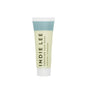 A travel-size tube of Indie Lee Purifying Face Wash features a blue cap and label, with yellow-green hues highlighting Clarity, Calm, Chlorophyll, and Papaya—ideal for gentle makeup removal and refreshed skin.