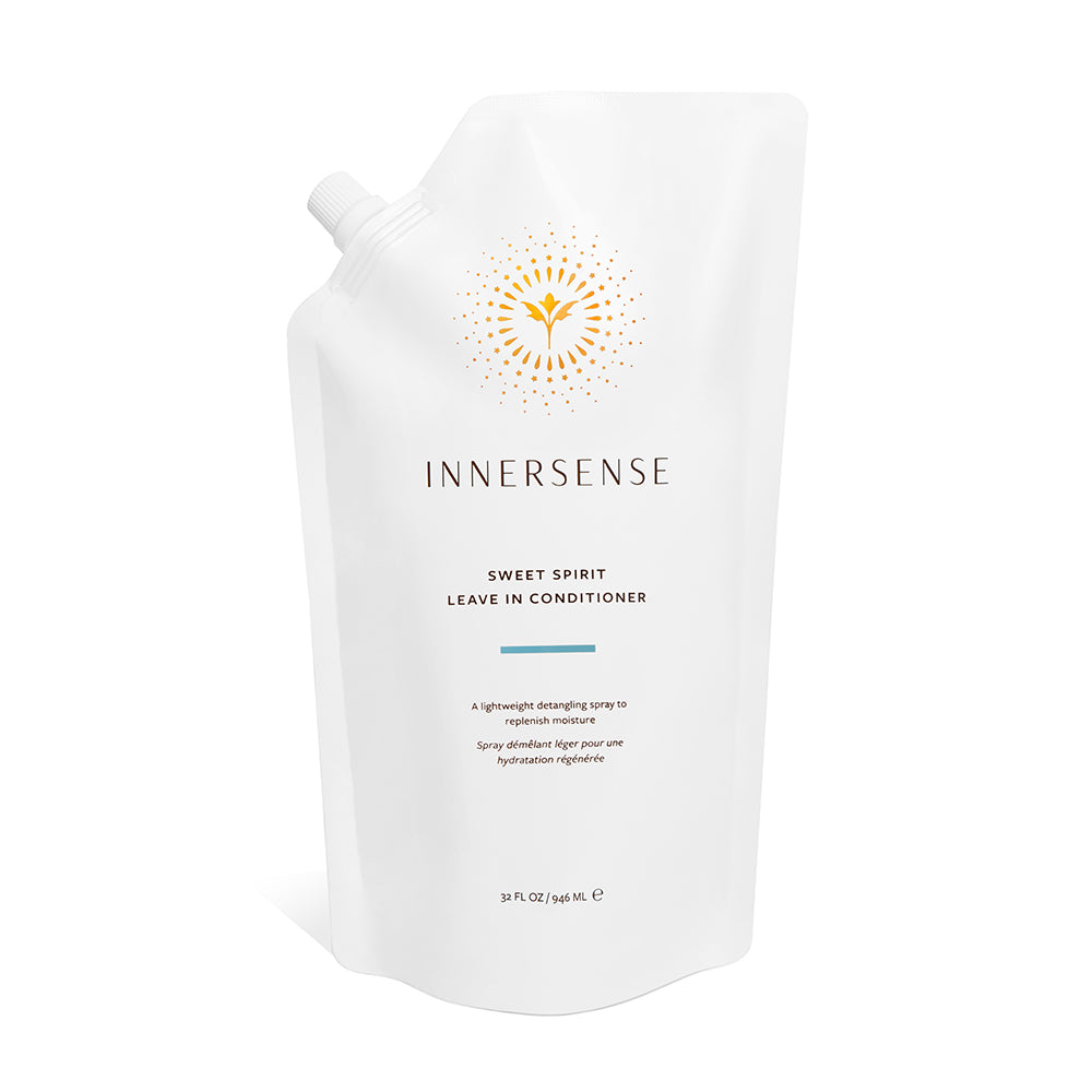 A white refill pouch of Innersense Organic Beauty Sweet Spirit Leave In Conditioner, featuring a gold sunburst logo and minimalist text, delivers nourishing care with certified organic plant extracts and emollient oils.
