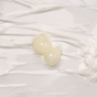 Two pieces of ravioli with a glossy, pale filling rest on a smooth, creamy white surface that resembles the luxurious, glowy finish of the Dew Bomb Glowy Hydra-Milk Starter Kit by IZZY Zero Waste Beauty.