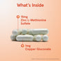 Six white Zinc Balance 15mg Veggie Caps from Jarrow, each labeled with 15mg Zinc L-Methionine Sulfate and 1mg Copper Gluconate, stacked on a peach gradient background. Image for illustration only appears at the bottom.