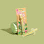 A Jack N Jill Silicone Toothbrush STAGE 2 for babies is shown in yellow packaging labeled with its name and safety shield, with one toothbrush inside the pack and another displayed on a light green background.
