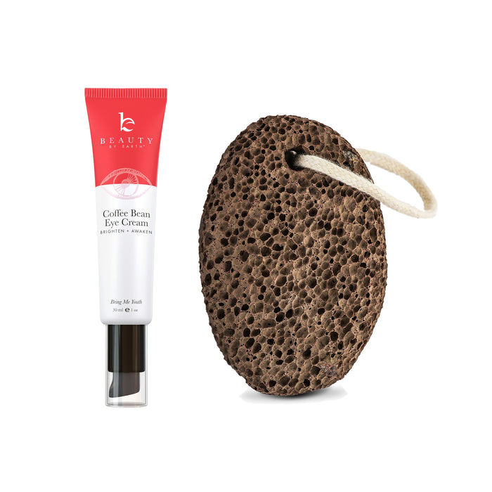 A tube of Beauty by Earths Coffee Bean Awakening Eye Cream, designed to reduce puffy eyes, sits beside a dark brown pumice stone with a white looped string as a free gift.
