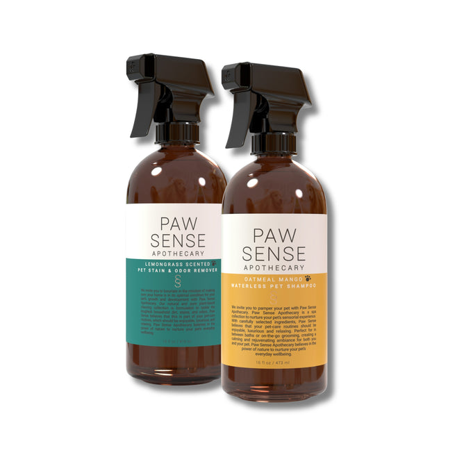 Two eco-friendly amber spray bottles from Paw Sense: Waterless Pet Shampoo with an orange label and Stain and Odor Remover with a teal label.