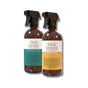 Two eco-friendly amber spray bottles from Paw Sense: Waterless Pet Shampoo with an orange label and Stain and Odor Remover with a teal label.