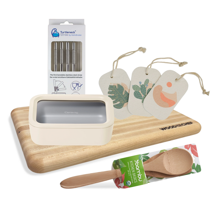 The Grove Collaborative Highest Impact Kitchen Swap Set includes non-toxic food storage, a microplastic-free cutting board, metal straws, three illustrated gift tags with string, and a bamboo spoon in green packaging.