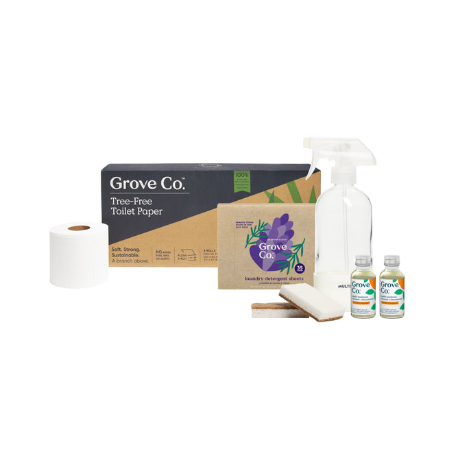 Displayed on a white background is the Grove Co. Highest Impact Swaps Gift Set by Grove Collaborative, featuring a roll of bamboo toilet paper, a box labeled Grove Co. Tree-Free Toilet Paper, a spray bottle of multi-purpose cleaner concentrate, laundry detergent sheets, two bottles of cleaning solution, and two cleaning sponges.