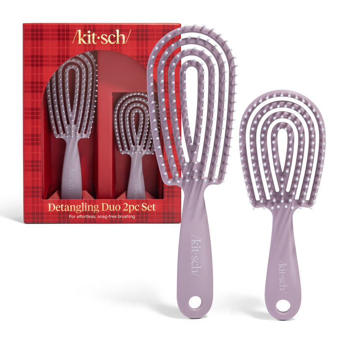 Two lavender brushes with flexible bristles, shown inside and outside a red plaid Kitsch box labeled Hair Detangling Brush Duo Gift Set for effortless, snag-free brushing and less hair breakage.