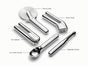 The Caraway 5-Piece Stainless Steel Kitchen Gadget Set includes a pizza cutter, garlic press, can opener, ice cream scoop, and vegetable peeler—each labeled for easy use on a white background.