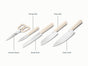 The Caraway 5 Piece Knife Set includes kitchen shears, bread, paring, prep, and chef’s knives with ergonomic cream handles and German stainless steel blades, shown on a white background.