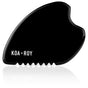 The KOA + ROY Large Black Obsidian Body Gua Sha Tool features a curved, wavy shape and “KOA + ROY” in white on its smooth surface—ideal for lymphatic drainage inspired by traditional Chinese medicine.
