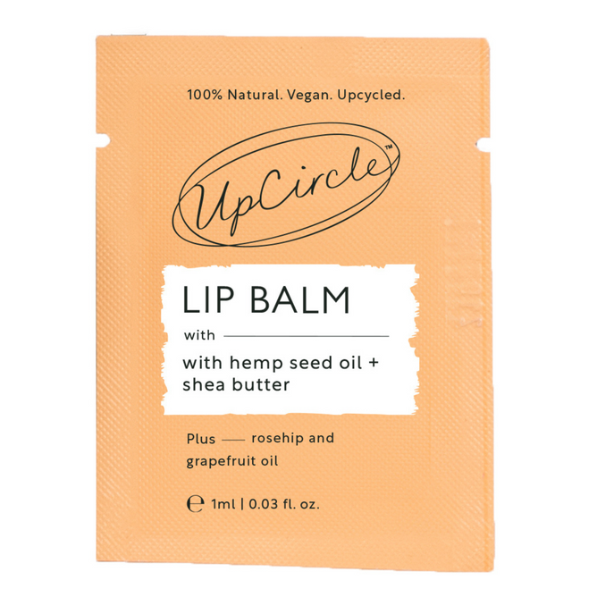The UpCircle Lip Balm - Samples orange packaging highlights its natural, vegan, upcycled nature. Enriched with hemp seed oil, shea butter, rosehip, and grapefruit oils, it delivers a smooth blend. Its clean, minimal design underscores a commitment to eco-friendliness.