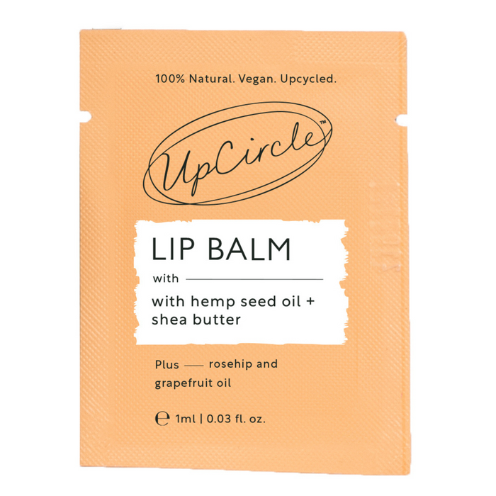 The UpCircle Lip Balm - Samples orange packaging highlights its natural, vegan, upcycled nature. Enriched with hemp seed oil, shea butter, rosehip, and grapefruit oils, it delivers a smooth blend. Its clean, minimal design underscores a commitment to eco-friendliness.