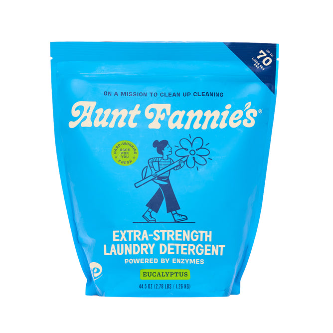 Bright blue pouch of Aunt Fannie's Laundry Detergent Powder - Extra Strength, with a walking person holding a flower, eucalyptus scent, product details, and "enzyme powered" formula tough on stains featured on the front.