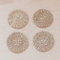 Four round LIKHA Abaca Coasters, set of 4, are arranged in a square on a light wooden surface. Each sustainably sourced, handwoven coaster features a spiral pattern and a natural beige color.