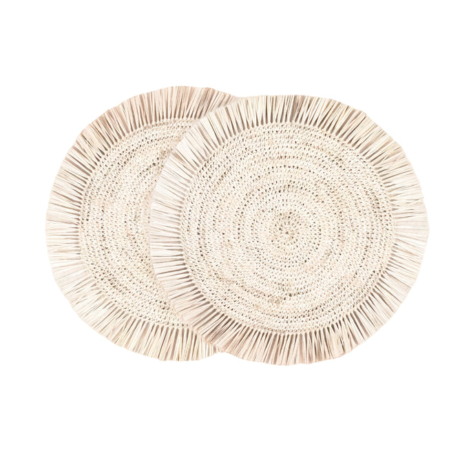 Two LIKHA Raffia Fringe Placemats, set of 2, handwoven by Filipino artisans with fringed edges, are overlapping on a white background.