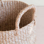 Close-up of the LIKHA Abaca Cylinder Tabletop Baskets, a nested set of 2 with sturdy handles, handwoven from natural Manila hemp fibers and displayed on a light wooden surface.