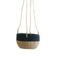 The LIKHA Abaca Round Hanging Planter features a handwoven two-tone design with natural beige on the bottom, dark blue on top, and four sturdy rope handles, shown suspended against a white background.
