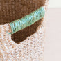 A close-up of the LIKHA Abaca Octagon Basket, ethically made from natural Abaca fiber with a green twine-wrapped handle, showcased on a light-colored surface.