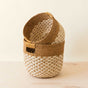 The LIKHA Abaca Round Bottom Basket set features two handwoven, Fair Trade Federation-certified baskets in natural beige and brown Manila hemp, nested together on a light wooden surface against an off-white background.