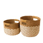 The LIKHA Abaca Round Bottom Basket, a nested set of 2 with built-in handles and natural brown and cream pattern, is handwoven from Manila hemp. Fair Trade Federation certified for ethical craftsmanship. Placed side by side on white background.