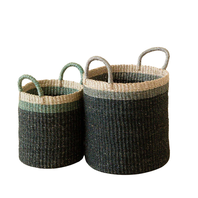 The LIKHA Abaca Cylinder Basket with handles is a nested set of 2 handwoven storage baskets, featuring a dark base with lighter rims. Made from sustainable manila hemp, these black baskets are shown side by side on a white background.