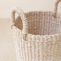 A close-up of the LIKHA Abaca Cylinder Vase, crafted from Manila hemp with two sturdy handles, sits on a light wooden surface against a neutral backdrop, showcasing its traditional handmade design.