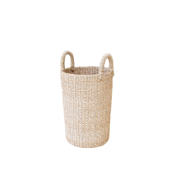 The LIKHA Abaca Cylinder Vase is a tall, cylindrical basket with two looped handles, crafted from ethically sourced Manila hemp using traditional techniques. It stands upright on a white background.