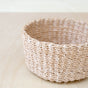 A close-up of the LIKHA Abaca Mini Trinket Basket, a sturdy, handwoven round tray made from natural abaca fibers. Its simple, rustic design is crafted sustainably and shown on a pale wooden surface.