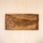 The LIKHA Acacia Serving Tray - Rectangle, featuring natural grain patterns, is displayed on a light-colored wooden surface.