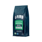 A 12 oz bag of Laird Superfood Perform Functional Mushrooms Ground DECAF Organic Coffee, Medium Roast. This adaptogenic blend comes in a dark blue bag with leaf patterns and green and white accents.
