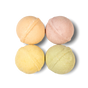 The Pacha Soap Co. Bath Bomb Set - Summer Garden features four pastel bath bombs—peach, pink, yellow, and green—arranged in a square on a white background.
