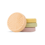 Four pastel-hued Pacha Soap Co. Shower Steamers from the Summer Garden set are stacked, with the top bar embossed with a leaf. The peach, yellow, green, and lavender steamers evoke fresh garden scents against a white background.
