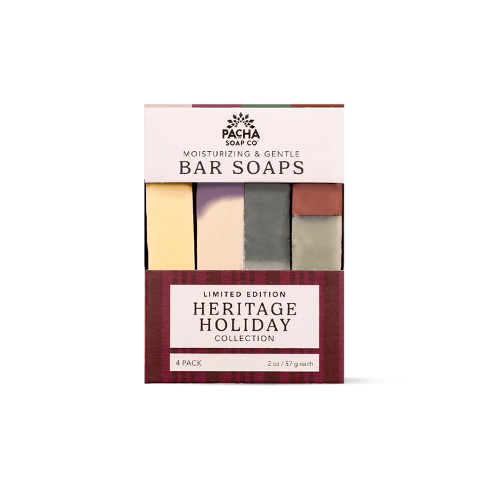 A Pacha Soap Co. Heritage Holiday Collection bar soap set in a box with a plaid base, containing four cold-processed bars in yellow, lavender, dark green, and reddish-brown.