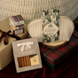 A Pacha Soap Co. Bar Soap & Soap Dish Gift Set - Vanilla Bean & Clove, a holiday soap collection, and a candle set presented with a small white cosmetic bag and wrapped gift boxes.