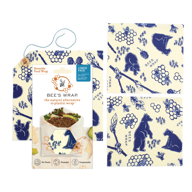 Bee’s Wrap Lunch Pack reusable food wraps by Bees Wrap, in blue and cream with bear, hive, and bee designs, offer an eco-friendly alternative to plastic wrap. Packaging shows the product partially holding a sandwich.
