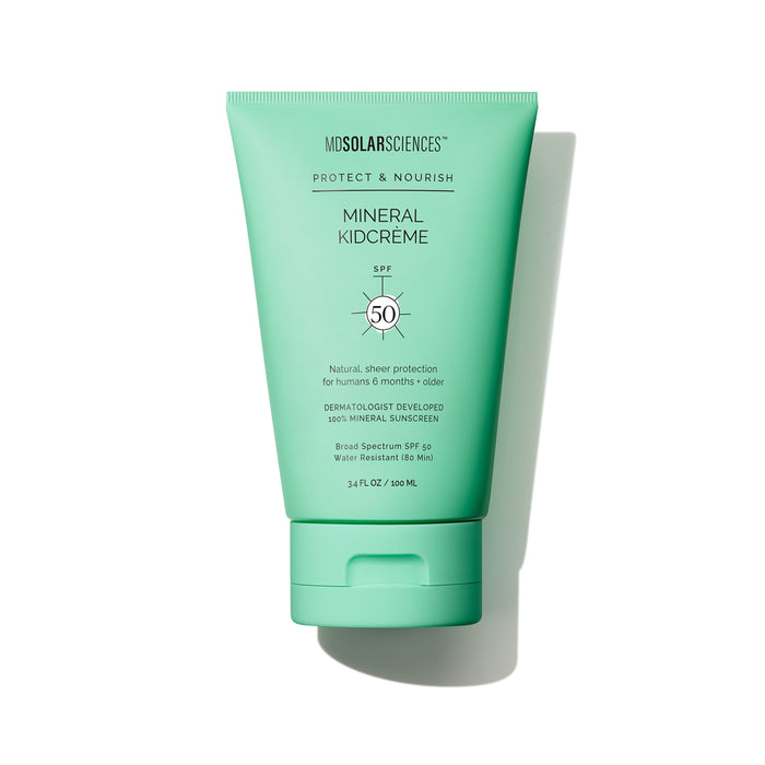 A green tube of MDSolarSciences Mineral KidCrème SPF 50 sunscreen standing upright on a white background, with text highlighting its mineral formula and suitability for children.
