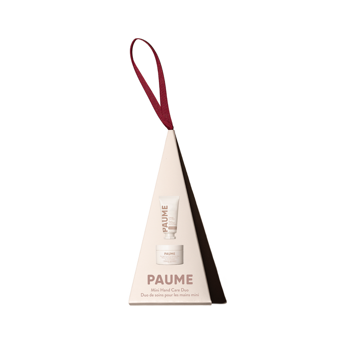 A triangular cream box with a red loop holds the PAUME Mini Hand Care Duo - Ornament, featuring a probiotic hand balm and hydration mask in mini tube and jar for ultimate hand care.