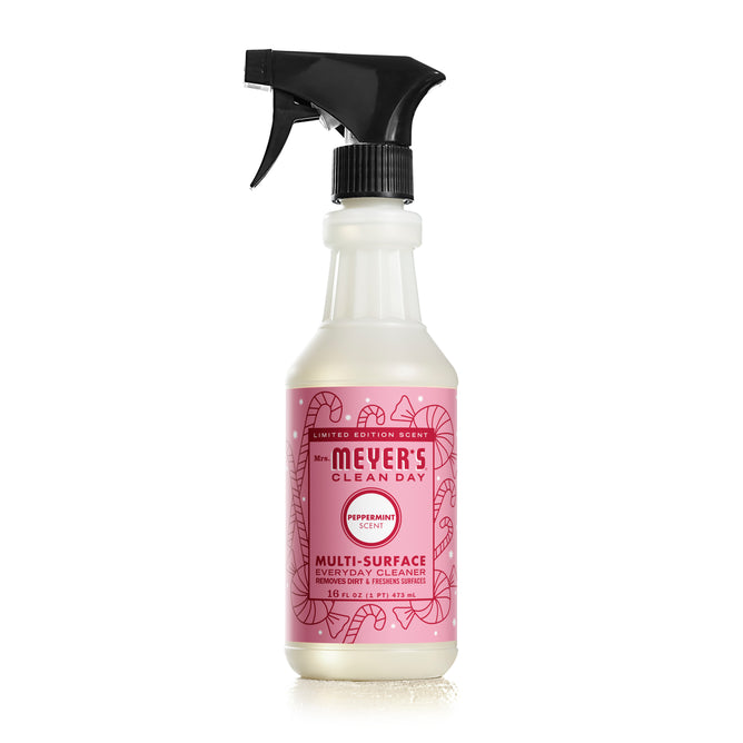 Mrs. Meyers Multi-Surface Cleaner comes in a garden-inspired peppermint scent with a pink label featuring candy cane illustrations, essential oils infusion, and is equipped with a black trigger spray nozzle for easy use.