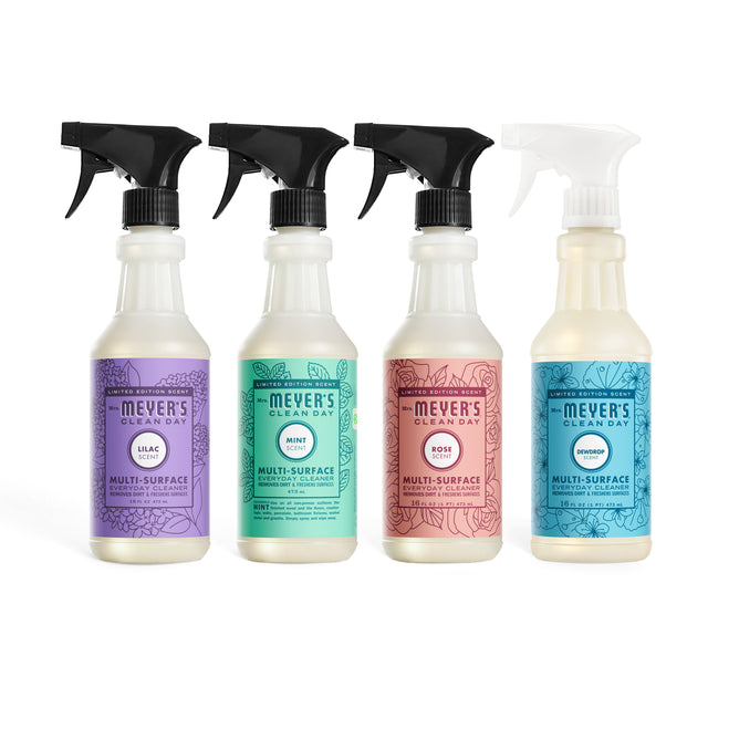 Four bottles of Mrs. Meyer's Multi Surface Cleaner Spring Collection are lined up: Lilac (purple label), Mint (blue label), Rose (pink label), and Pear Tree (white label).